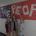 Fifth graders Sammi Walker, Liv Permel, and Luke Marshall prepare to sign the "We the People" banner constructed at Princess Anne Elementary School to celebrate Constitution Day Sept. 17. Every student in the school had the opportunity to sign the giant banner while learning the meaning of the document's preamble.