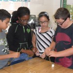 Kempsville Middle School sixth-grade students Brian Reid, Jasmyn Robinson, An Truong, and Matthew Warren practice their Habits of Mind during the Marshmallow Challenge. Students were tasked with building the tallest freestanding tower with spaghetti, tape, and string while resting a marshmallow on top of the structure. The students were required to employ collaborative skills to finish the task.